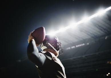 Quarterback preparing to throw pass at night